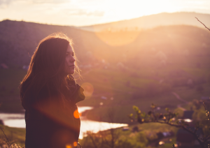 a woman looking into the distance, a lake in the background